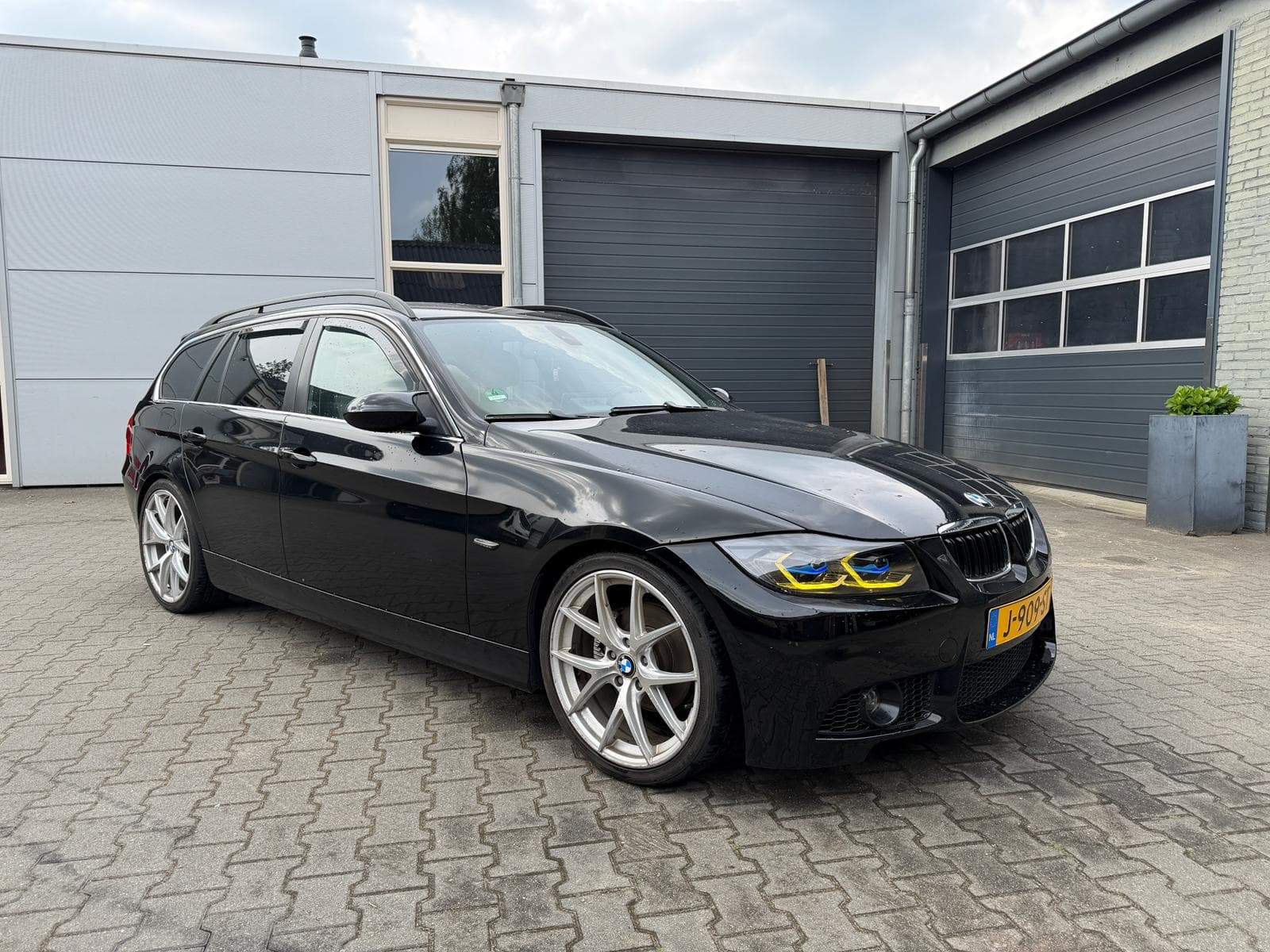 Originele telefoonfoto van een zwarte auto voor de showroom